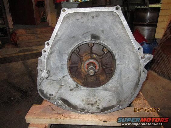 Aluminum transmission bell housing with a central circular opening showing a splined shaft and orange seal