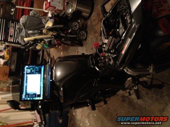 Motorcycle with a computer screen mounted on handlebars, showing a diagnostic interface