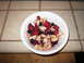1990 Ford Bronco - A white bowl filled with strawberries, blueberries, raspberries, and banana pieces sits on a speckled countertop.