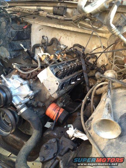 engine bay with engine parts, including oil filter and valve cover