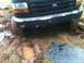 1994 Ford F-150 - A 1994 Ford F-150 is stuck in the mud, with its front tires partially submerged.