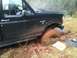 1994 Ford F-150 - This truck is deeply stuck in the mud, with one wheel completely submerged in the mire.