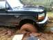1994 Ford F-150 - A Ford truck is stuck in thick mud, with one tire completely submerged.