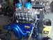 1992 Ford Bronco - A highly customized engine with a prominent supercharger and vibrant blue components sits ready for installation.