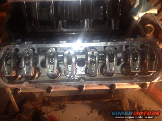 Engine valve train with rocker arms and springs visible inside a disassembled engine block