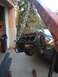 1992 Ford Bronco - Engine block is being lifted by a crane in front of a garage.