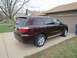 2012 Dodge Durango - The rear passenger side of a maroon SUV is shown parked on a concrete driveway.