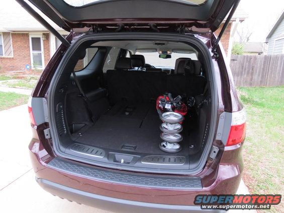 Maroon SUV's open trunk with golf bag and stroller wheels inside