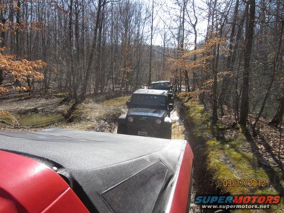 Line of Jeeps on a muddy forest trail. Date stamp 03/17/2012