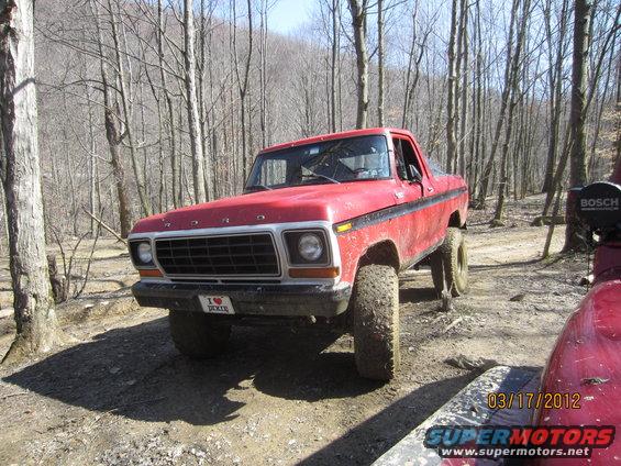 Red 1979 Ford Bronco with lifted suspension and off-road tires