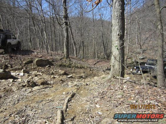 1979 Ford Bronco and another off-road vehicle on a rocky, wooded trail