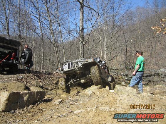 Jeep Wrangler climbing over rocks with another vehicle and people nearby. Date stamp 03/17/2012