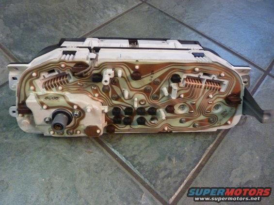 Back of a car instrument cluster showing circuit board and wiring connections