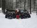 1994 Ford Bronco - Several Jeeps are gathered in a snow-covered forest, with people interacting around the vehicles.