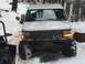 1994 Ford Bronco - A person waves from the window of a white van equipped with a heavy-duty bumper and winch, navigating a snowy terrain.