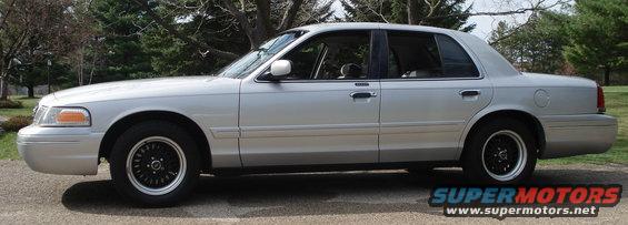 Silver 2000 Ford Crown Victoria sedan with black wheels, side view
