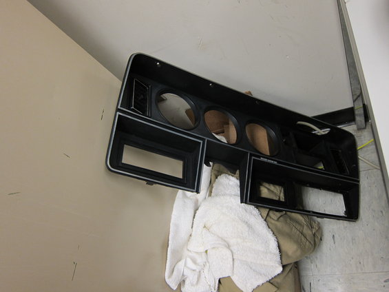 Dashboard instrument cluster bezel with openings for gauges and radio