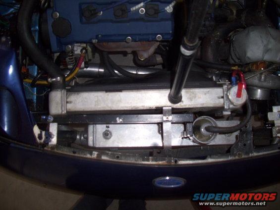 Blue car engine bay with a large radiator, intercooler, and blue engine block. Some hoses and wiring are visible
