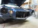 1973 Chevrolet Camaro - Front view of a blue coupe with its hood open, showing a disassembled front end and missing grille.
