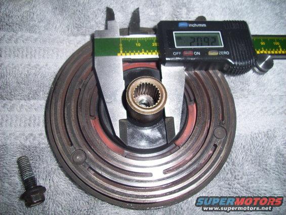 Digital caliper measuring a clutch assembly. A bolt is to the left