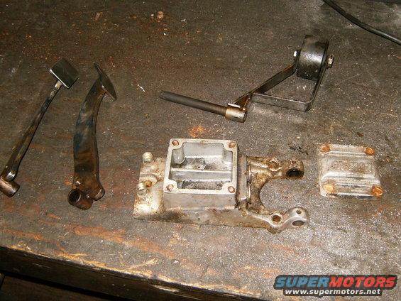 Brake master cylinder housing and cap with linkage parts on workbench