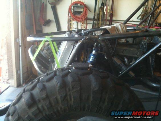 Close-up of a buggy's tire and roll cage in a garage