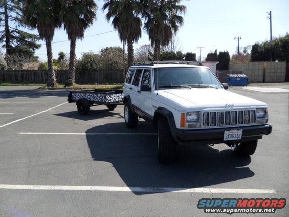 1994 Jeep Cherokee 3q-front view, white, towing a patterned trailer