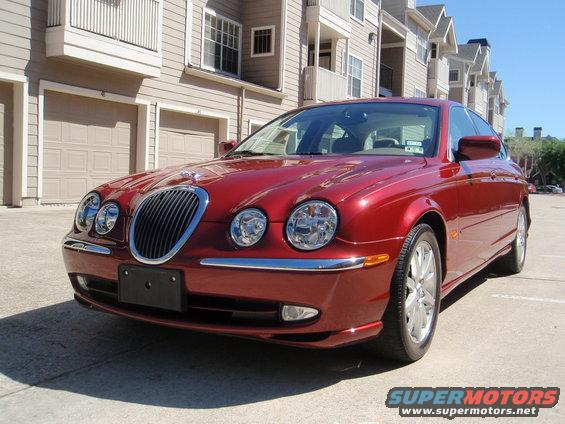 Red Jaguar S-Type parked in front of a building. The car is a 2000 model
