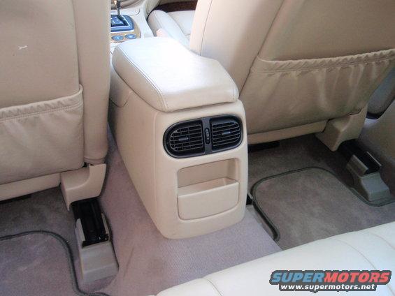 Interior shot of car's rear center console with air vents and storage, between the front and rear seats