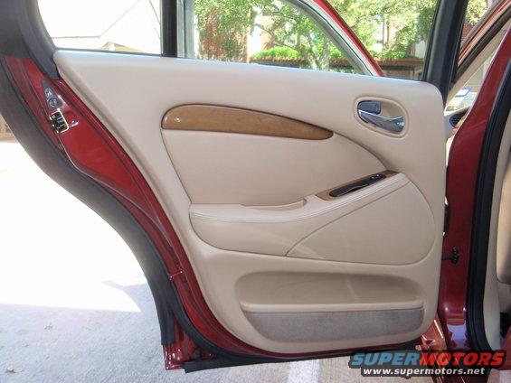 Interior door panel with wood trim and beige upholstery