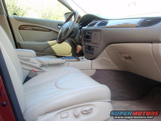 Car interior with tan leather seats, wood trim, and dashboard