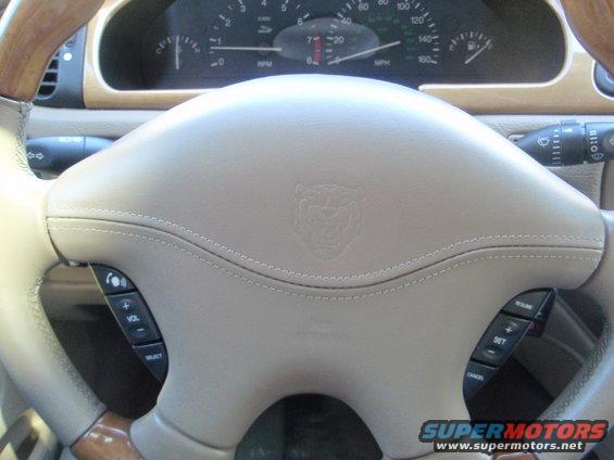 Interior shot of a 2000 Jaguar S-Type showing the steering wheel with Jaguar emblem and dashboard gauges