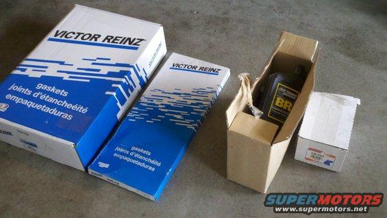 Two Victor Reinz gasket boxes, a bottle of BR oil, and a small white box on a concrete floor