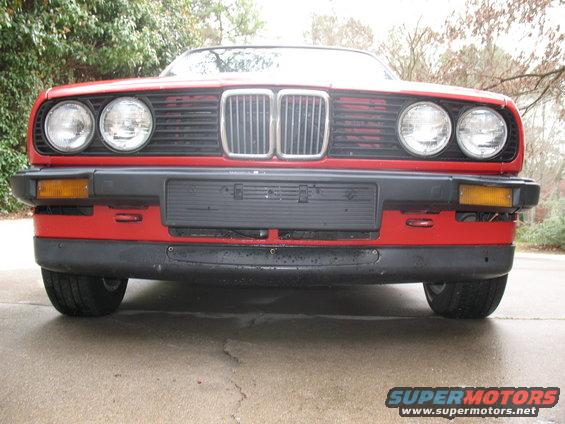 Red 1986 BMW 3 Series front end with dual headlights and grille