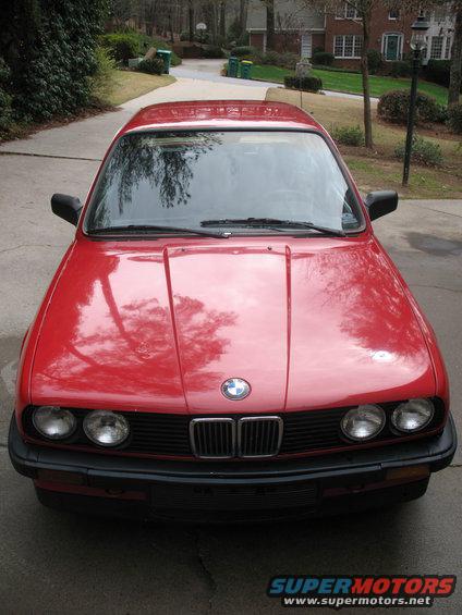 Red 1986 BMW 3 Series sedan, front view, parked on driveway
