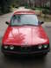 1986 BMW 3 Series - Front view of a red 1986 BMW 3 Series sedan with its iconic grille and headlights visible.