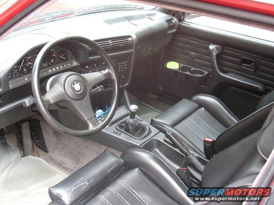 Interior of a 1986 BMW 3 Series showing dashboard, steering wheel, and seats
