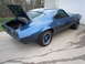1973 Chevrolet Camaro - A blue coupe sits in a driveway with its trunk and hood open, revealing a spare tire in the trunk.