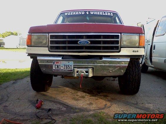 Red Ford F-Series truck front view with chrome bumper and winch