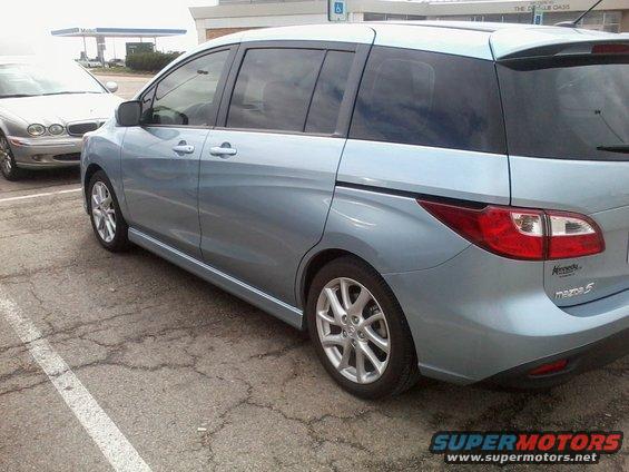 Light blue 2012 Mazda Mazda 5 side view with a silver sedan parked nearby