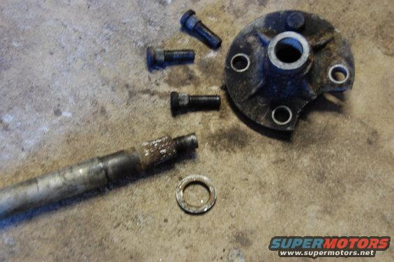 Disassembled hub and axle components on concrete floor