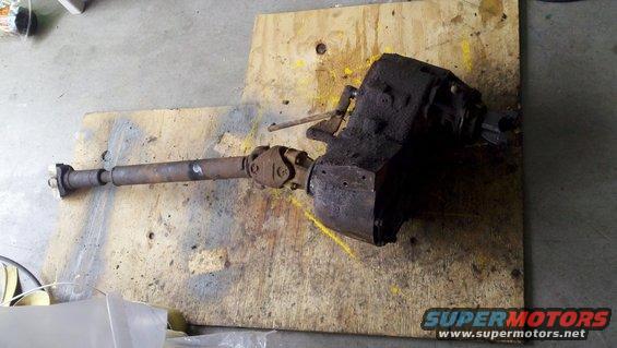 transfer case with driveshaft attached, sitting on plywood