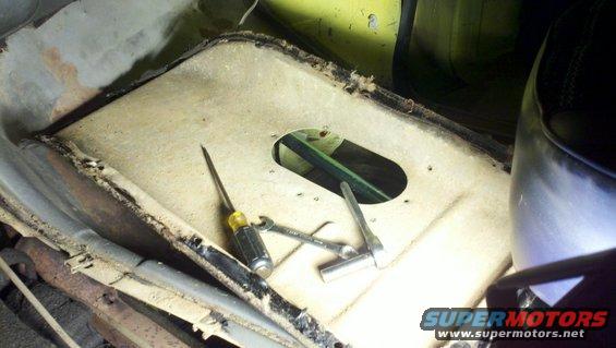 Interior floor with screwdriver and wrench near an opening
