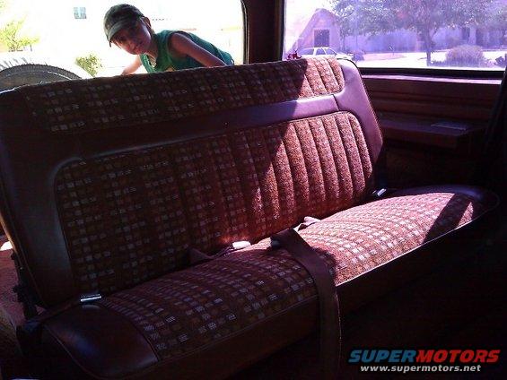 1981 Ford Bronco interior rear bench seat with patterned upholstery and seatbelts