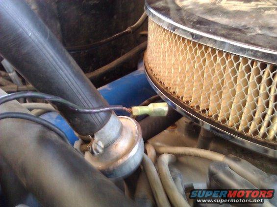 Close-up of engine bay showing air filter housing, hoses, and wiring