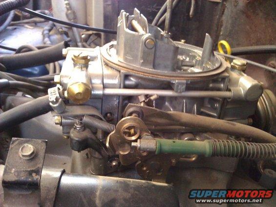 Close-up of a carburetor with linkage and hoses