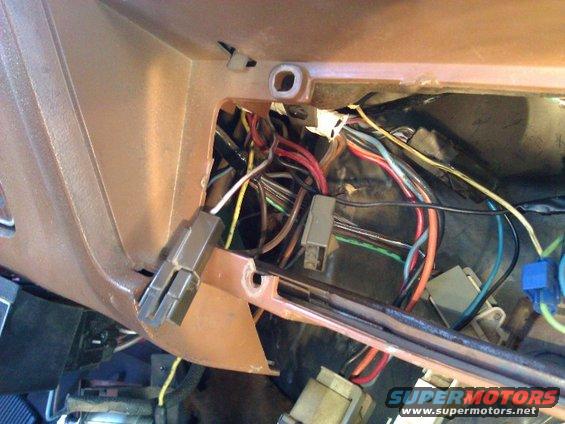 Close-up of a tangled vehicle wiring harness with brown plastic trim