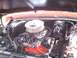 1978 Ford Bronco - The engine bay of a vehicle, a V8 engine with a chrome air cleaner and red block. The hood is open, revealing the engine components.