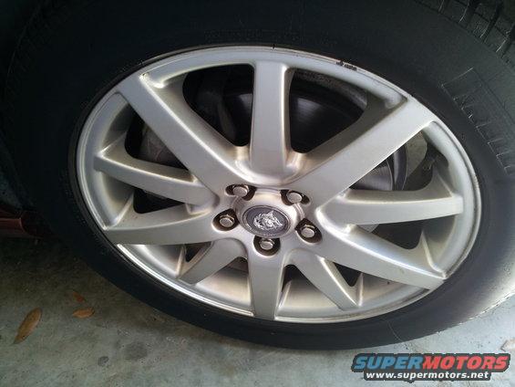 Silver Jaguar wheel with a Jaguar emblem on the hub, close-up view