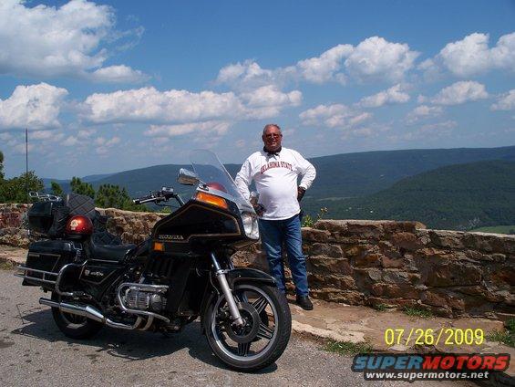 Black 1982 Honda GL1100I GW Interstate motorcycle parked on a scenic overlook with a man standing beside it